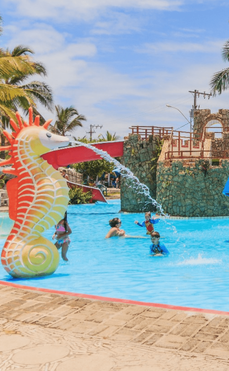Playground aquático infantil com um lindo cavalo marinho jorrando água em quatro crianças felizes e se divertindo.